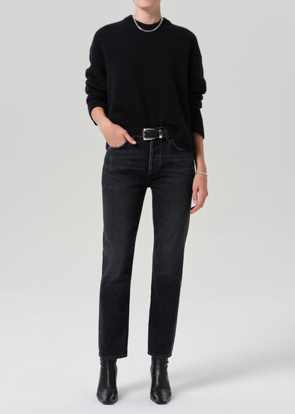 Person wearing a black outfit on a grey background
