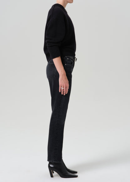 Person wearing a black outfit on a grey background