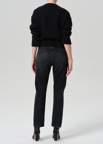 Person wearing a black outfit on a grey background