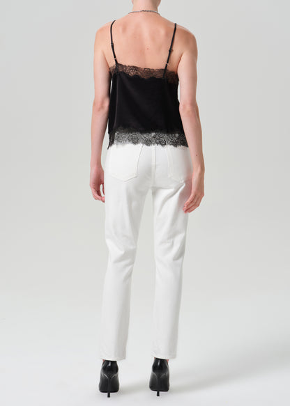 A model shown from the back wearing a black camisole top with lace trim and white trousers, standing against a grey background.