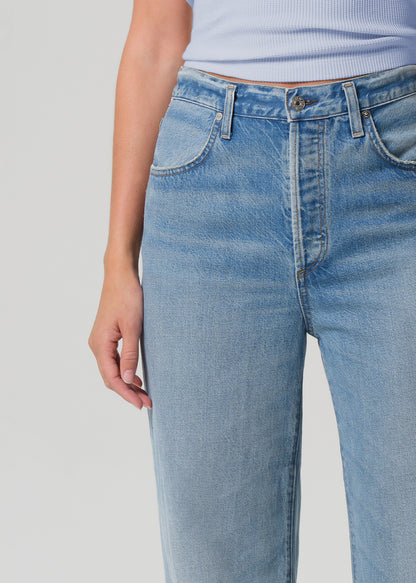 Light blue jeans worn by a person on a gray background