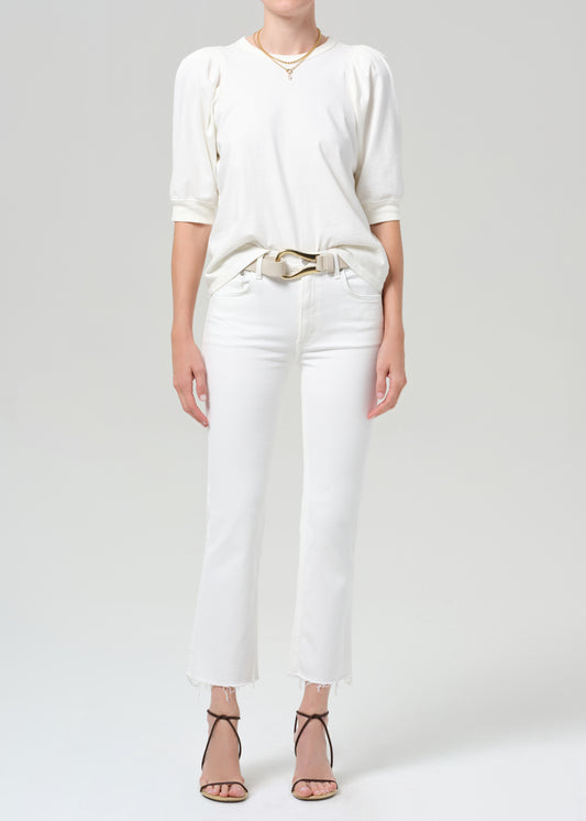 Person wearing a white shirt with white jean on a plain background