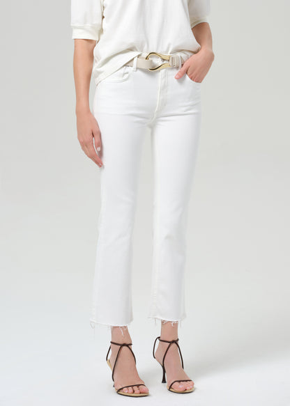 Person wearing a white shirt with white jean on a plain background