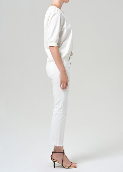 Person wearing a white shirt with white jean on a plain background