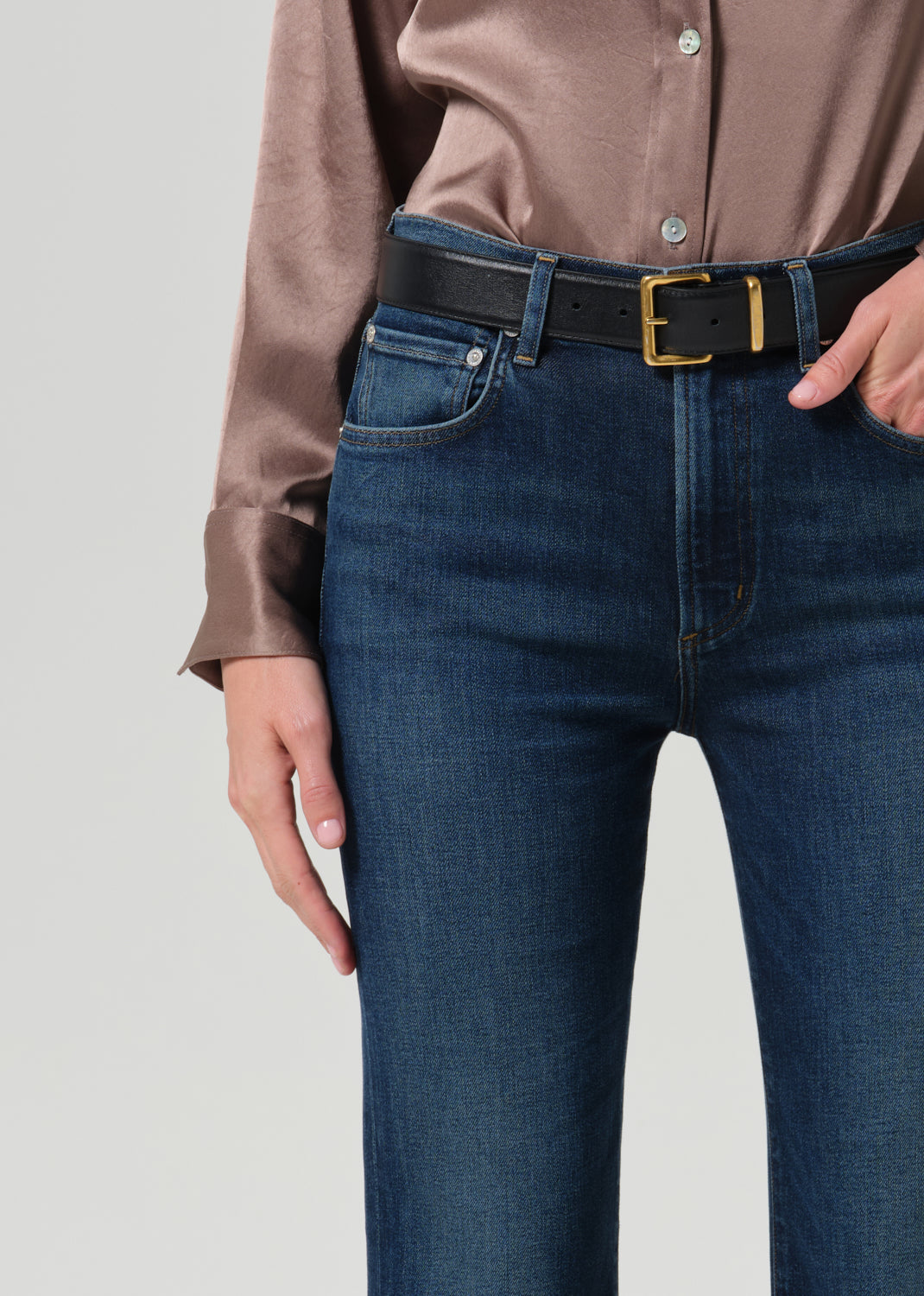 Close up of blue jeans on a grey background