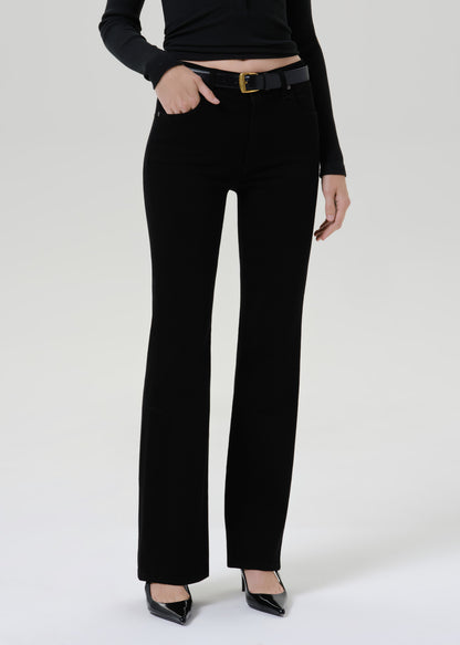 A model wearing black wide-leg trousers with a black belt and black pointed-toe heels, shown from the waist down against a grey background.