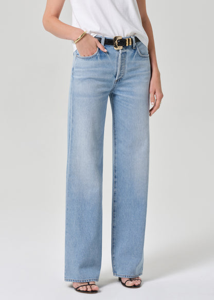 Light blue jeans worn by a person on a grey background