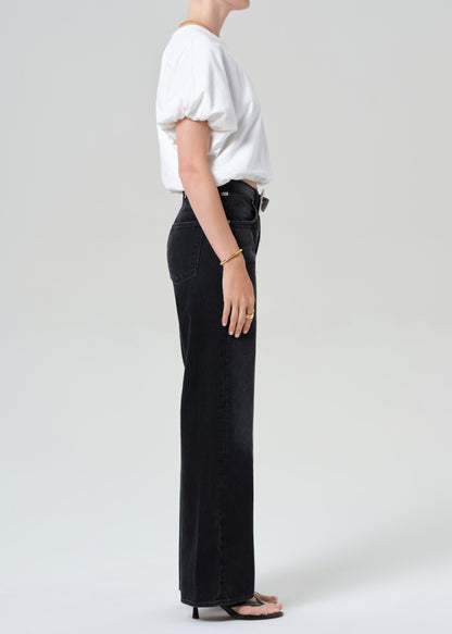 Person wearing a white top and black jeans on a plain background