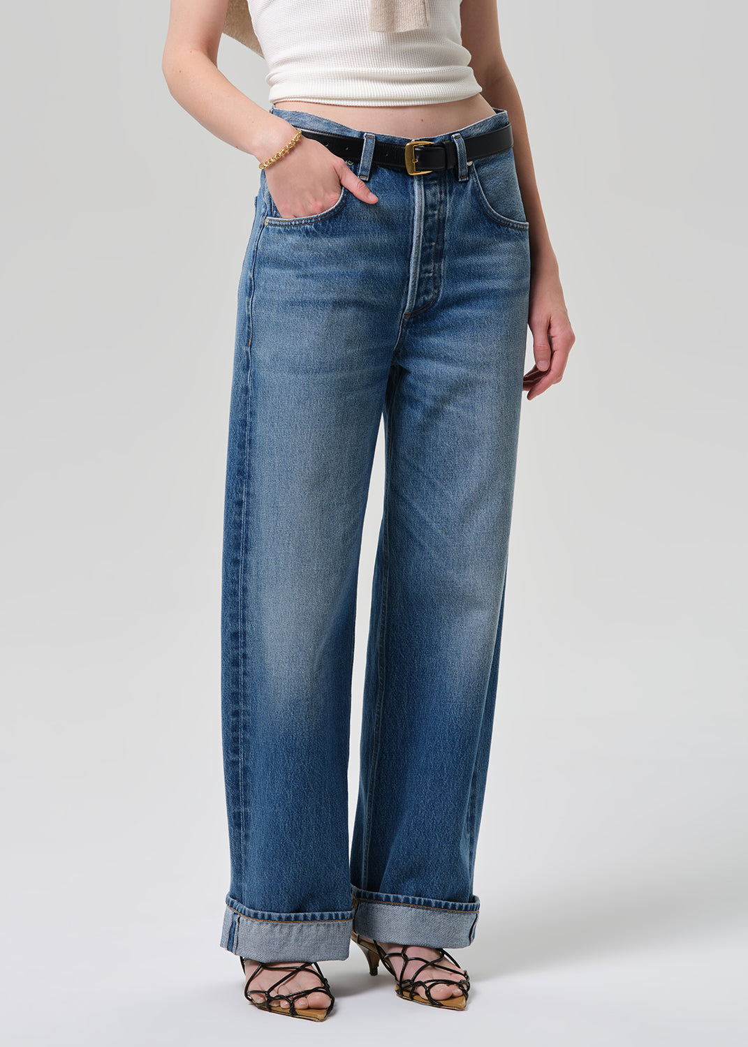 Person wearing blue jeans with a white background