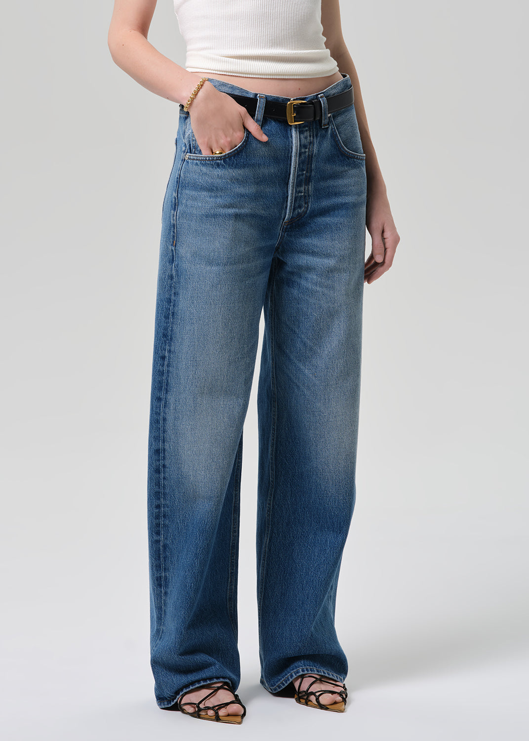 Person wearing blue jeans on a white background