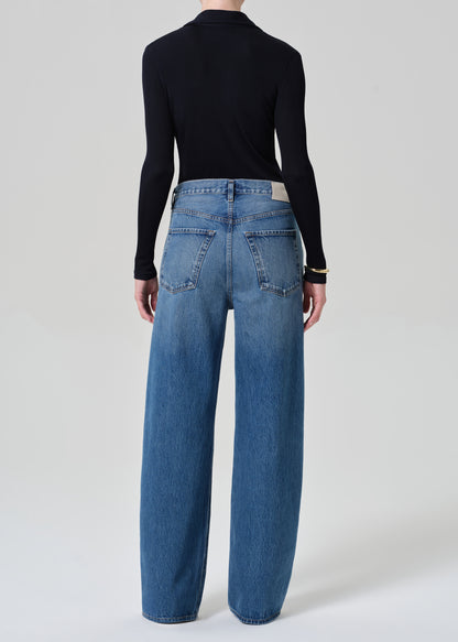 Person wearing blue jeans and a navy long-sleeve shirt on a white background