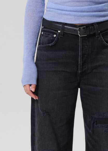 Person wearing black jeans and a light blue sweater on a plain background