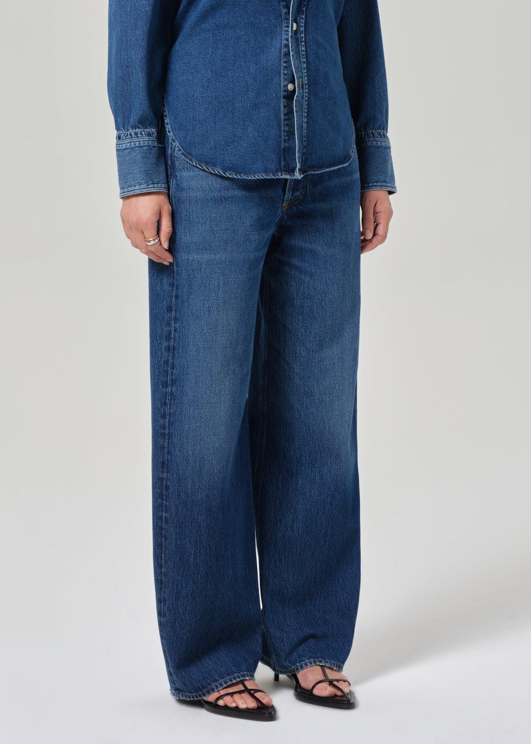 Person wearing a blue denim outfit on a plain background