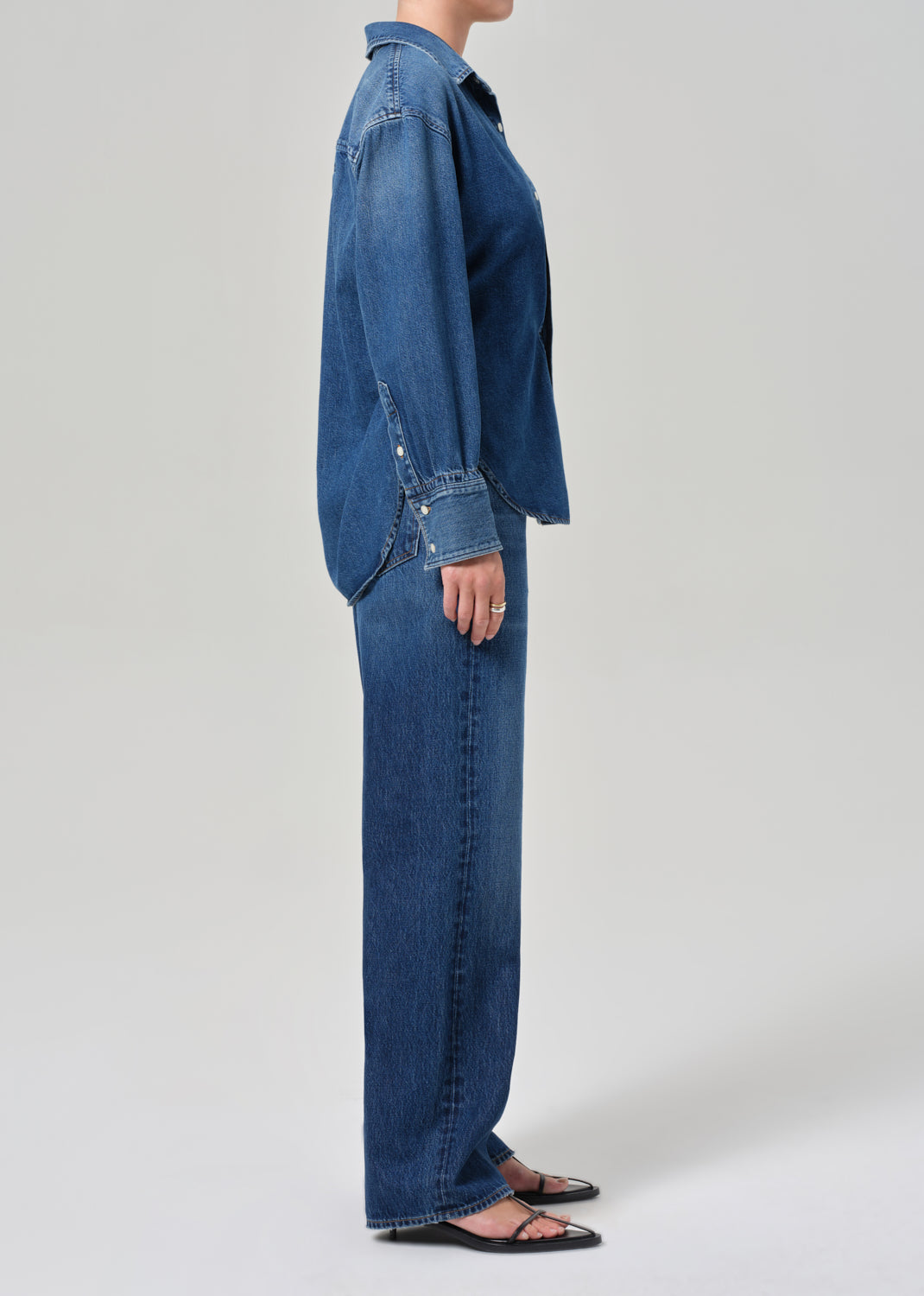 Person wearing a blue denim outfit on a plain background