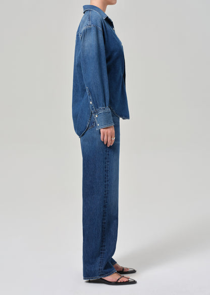 Person wearing a blue denim outfit on a plain background