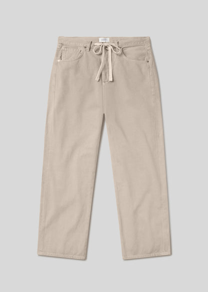 Light beige straight leg trousers with a drawstring waist, five-pocket design, belt loops, and button closure, front flat lay view on a grey background.