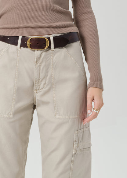 Person wearing a brown long-sleeve top and beige cargo pants on a plain background