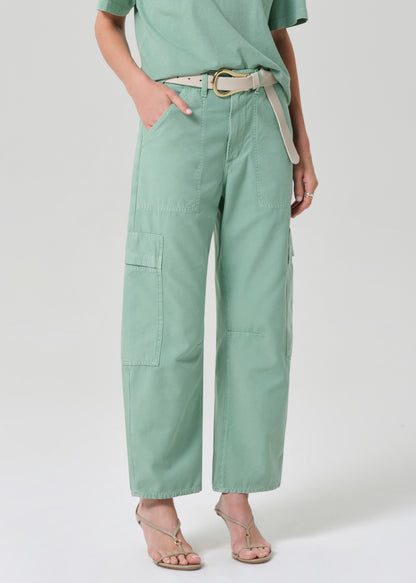 Person wearing a green outfit with cargo pants on a grey background