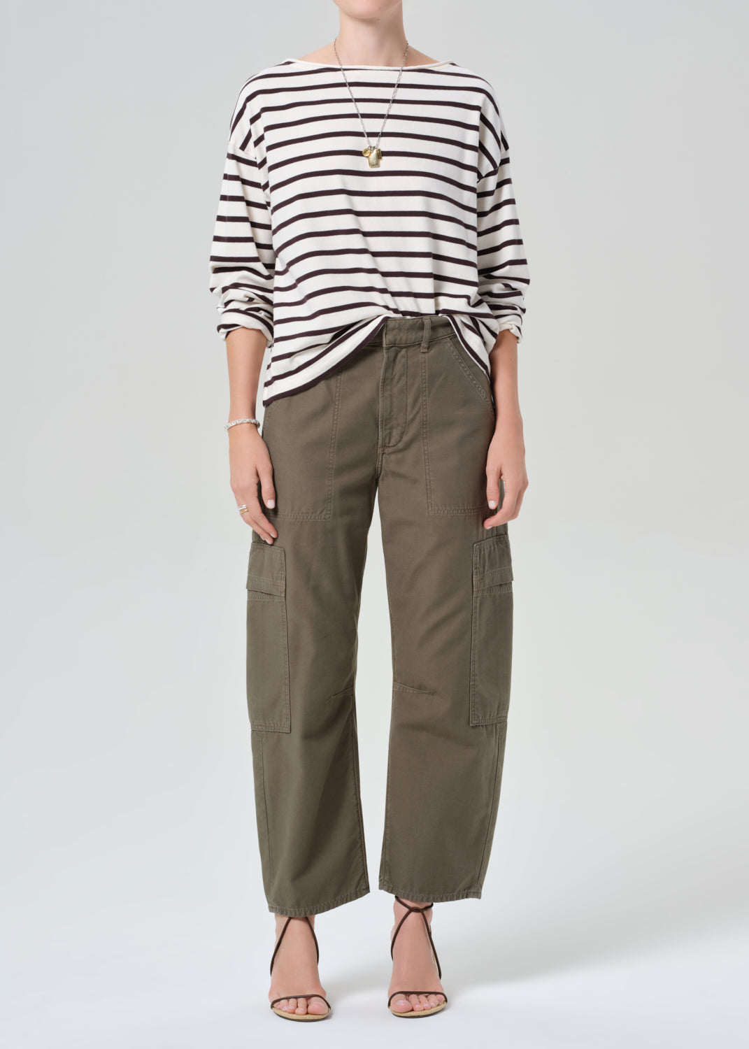 Person wearing a striped shirt and olive green cargo pants on a plain background