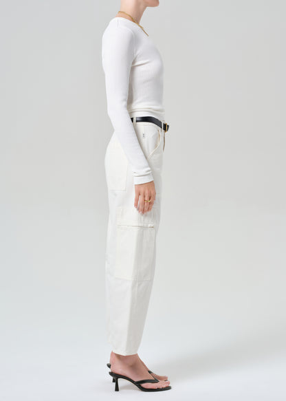 Person wearing a white outfit with a belt on a plain background