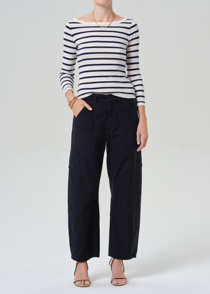 Person wearing a striped shirt with navy cargo pants on a light gray background