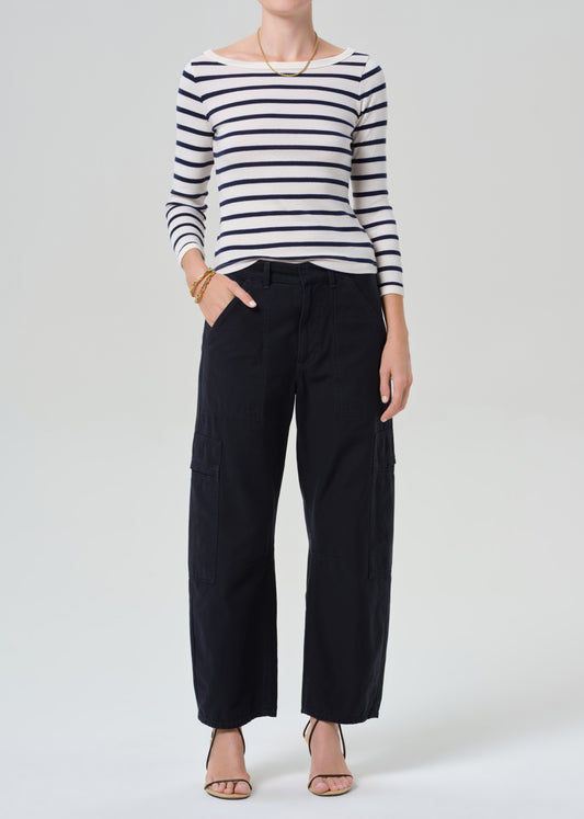 Person wearing a striped shirt with navy cargo pants on a light gray background