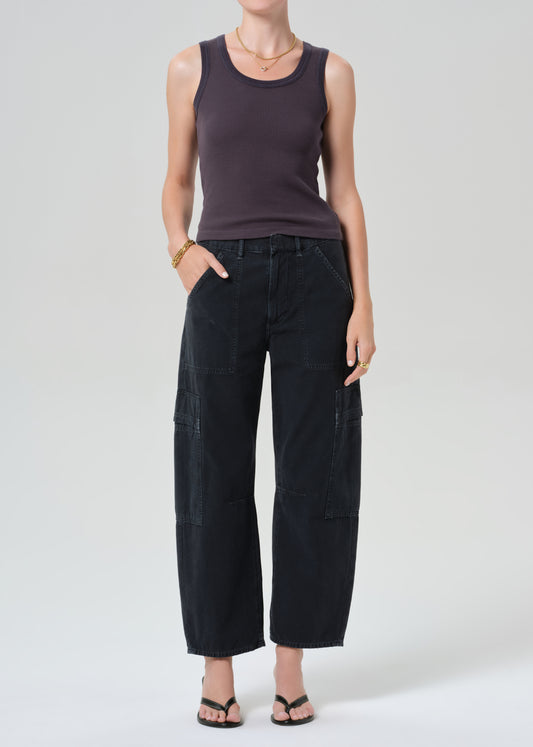 Person wearing a charcoal tank top and black cargo pants on a plain background