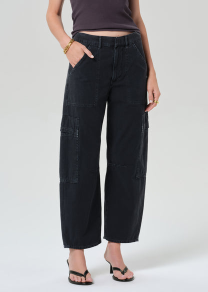 Person wearing a charcoal tank top and black cargo pants on a plain background