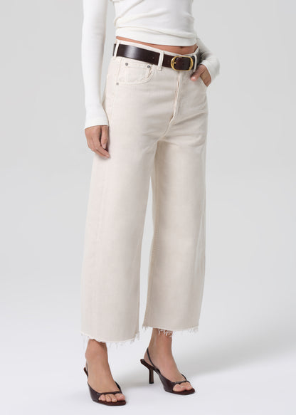 Person wearing white jeans and a white top on a plain background