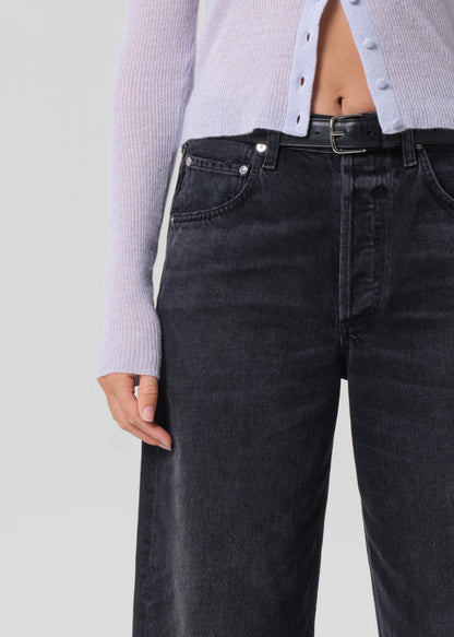 Person wearing black jeans with a light gray background