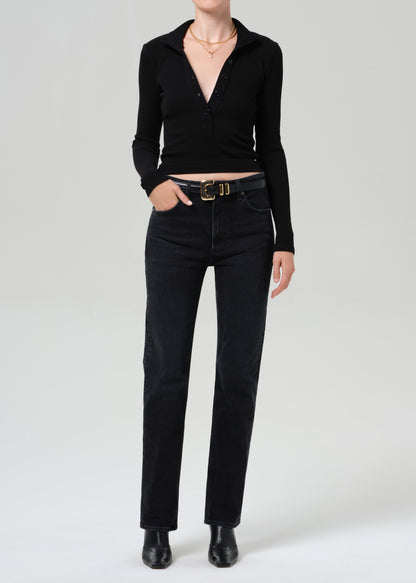 Person wearing a black sweater and black jeans on a plain background