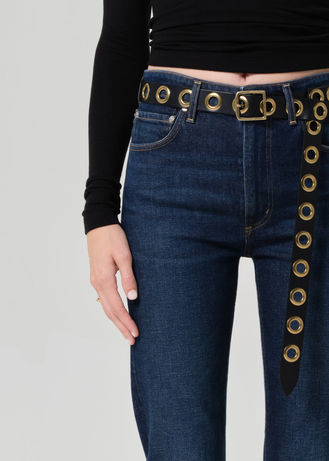 Blue jeans with decorative gold accents on a plain background