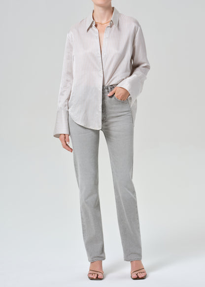 Person wearing a light gray shirt and pants on a grey background