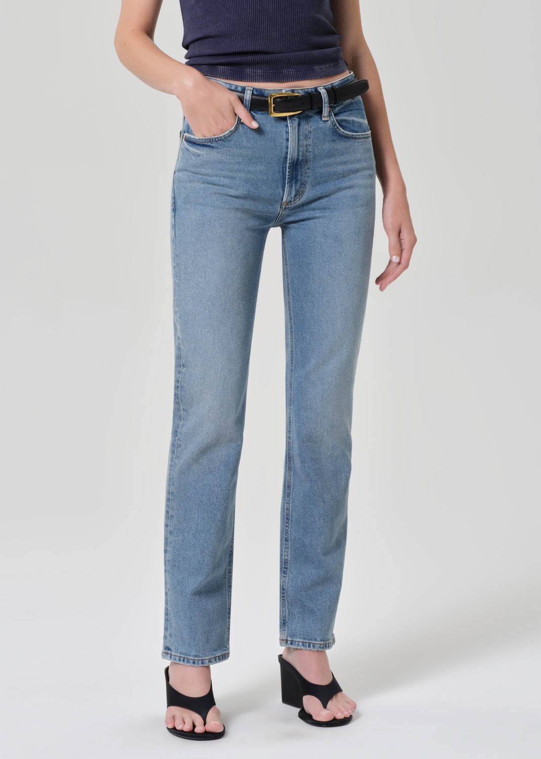 Person wearing a navy t-shirt and light blue jeans on a plain background