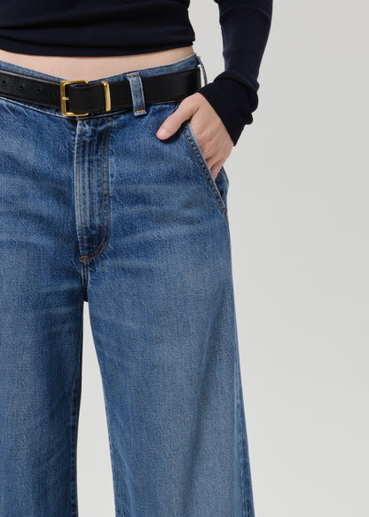 Close up shot of blue pants and black belt on a grey background