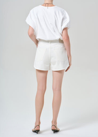Person wearing a white top and white shorts on a plain background