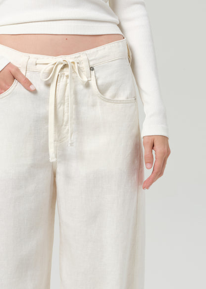 White pants with a drawstring waist on a plain background