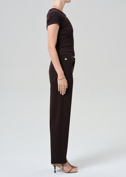 Person wearing a brown t-shirt and brown pants on a grey background