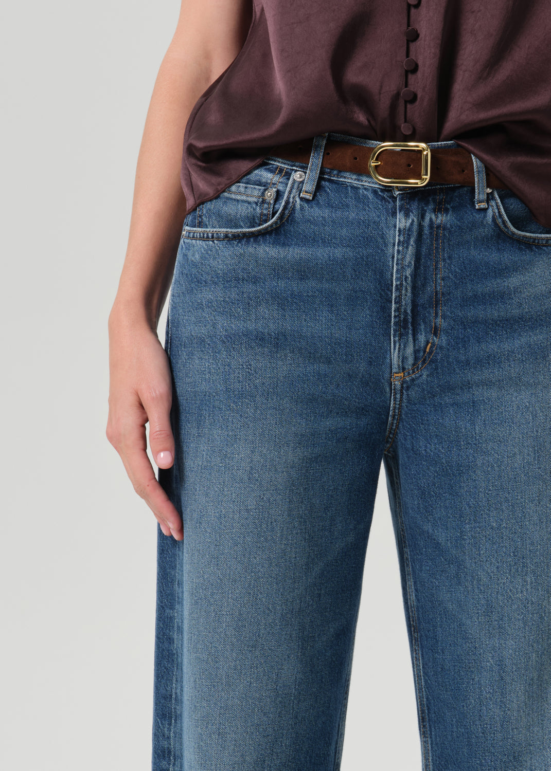 Close up shot of person wearing blue pants on a grey background