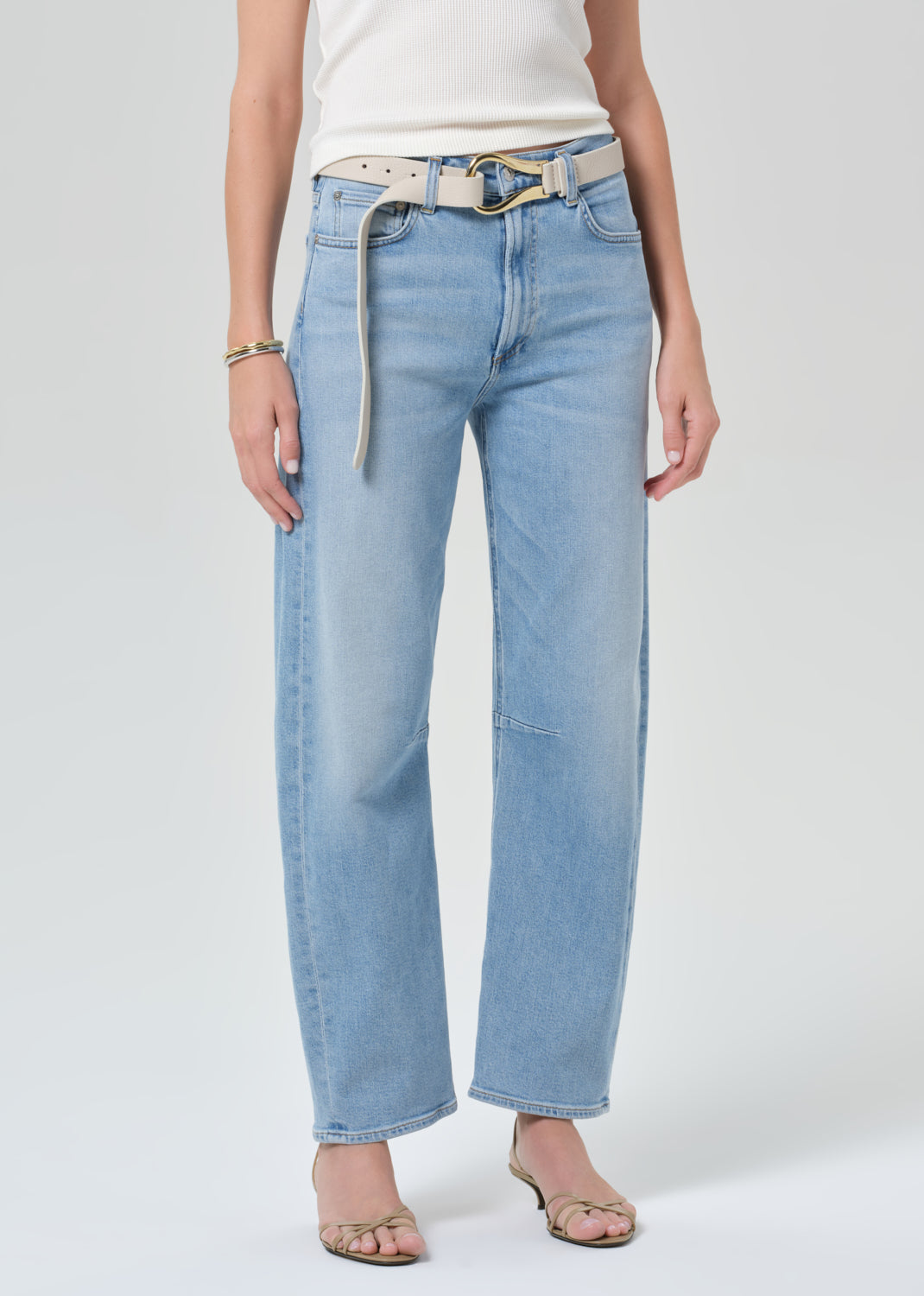 Light blue jeans worn by a person on a grey background