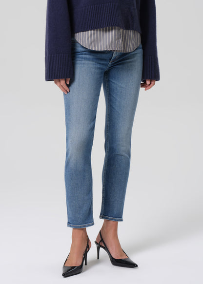 Person wearing blue jeans with a navy sweater and black high heels on a white background
