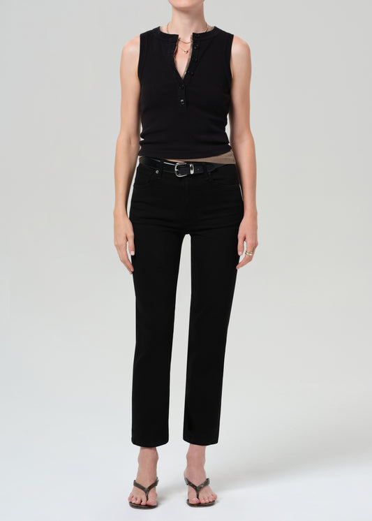 Person wearing a black sleeveless top and black pants on a plain background