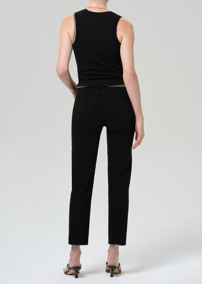 Person wearing a black sleeveless top and black pants on a plain background