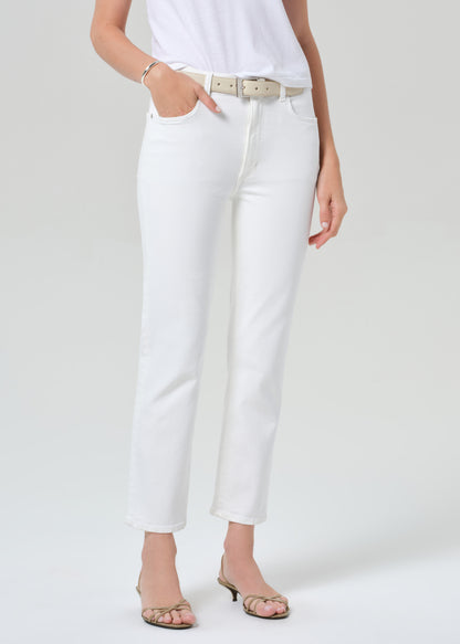 Person wearing a white t-shirt and white jeans on a light gray background