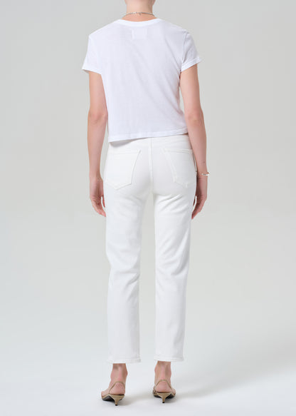 Person wearing a white t-shirt and white jeans on a light gray background