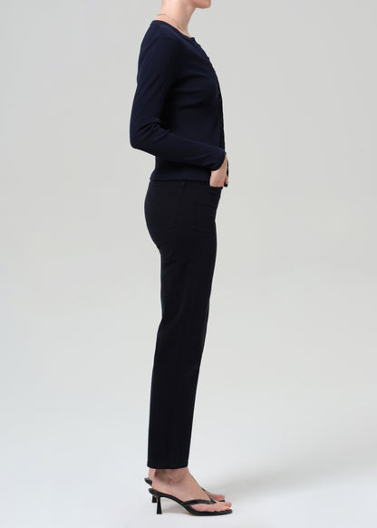 Person wearing a navy navy cardigan and navy pants on a grey background
