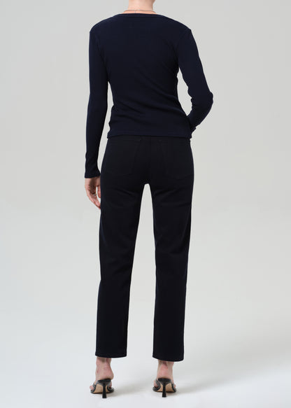 Person wearing a navy navy cardigan and navy pants on a grey background