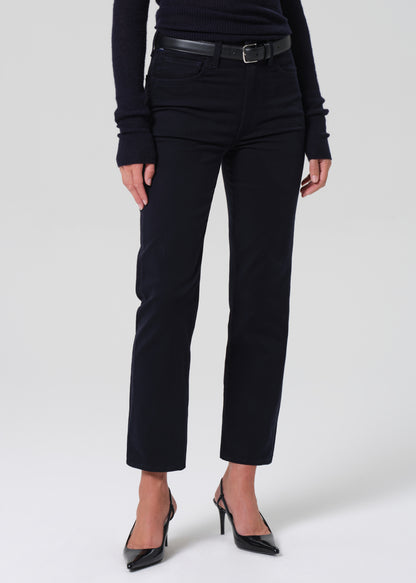 Person wearing a navy long-sleeve top and navy pants on a grey background