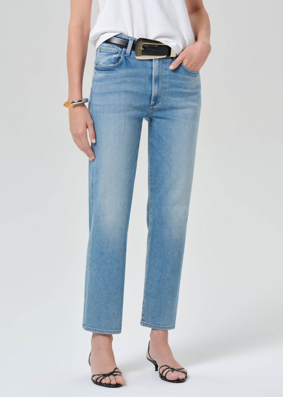 Person wearing light blue jeans on a white background