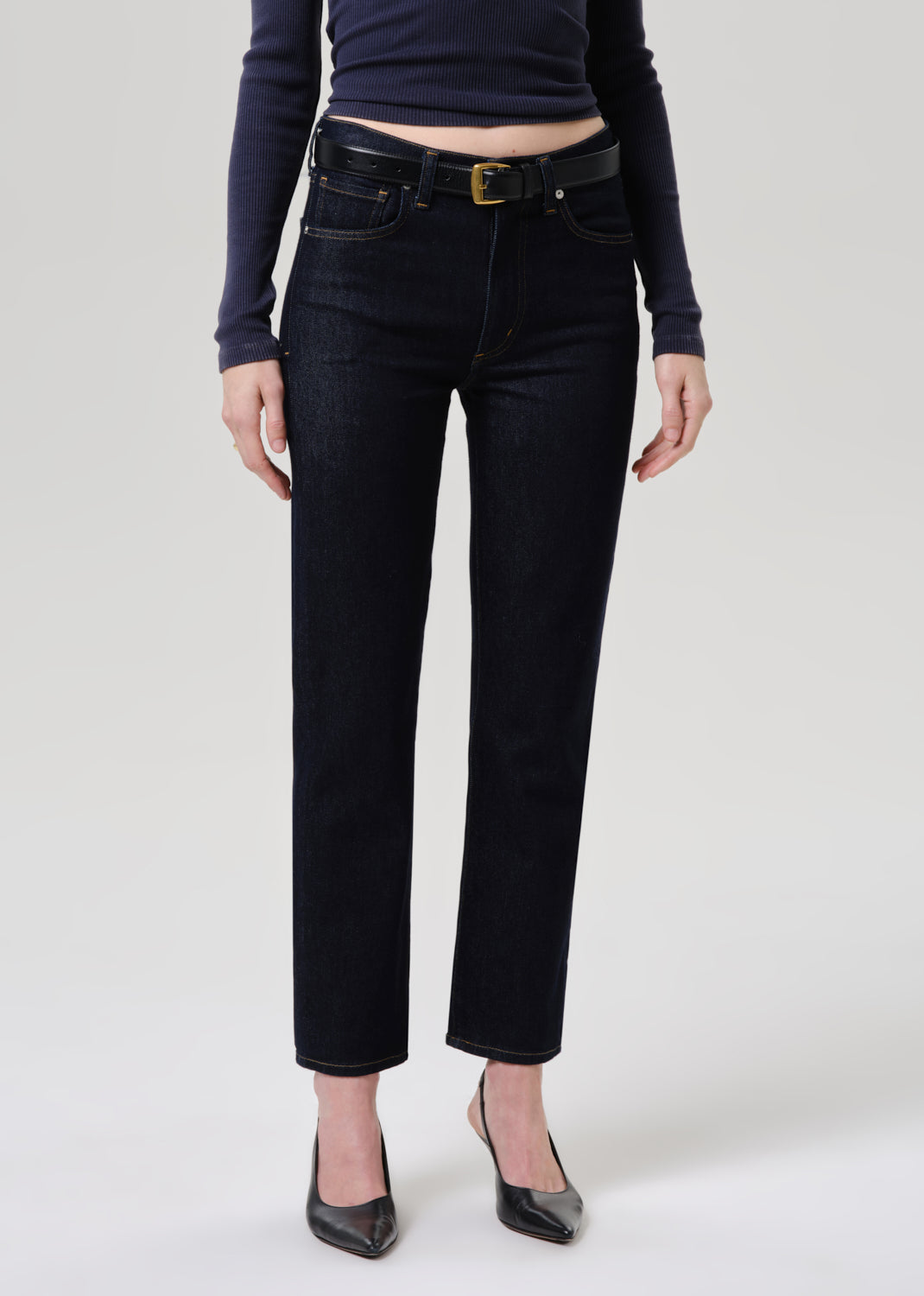 Person wearing black jeans and a dark top on a grey background